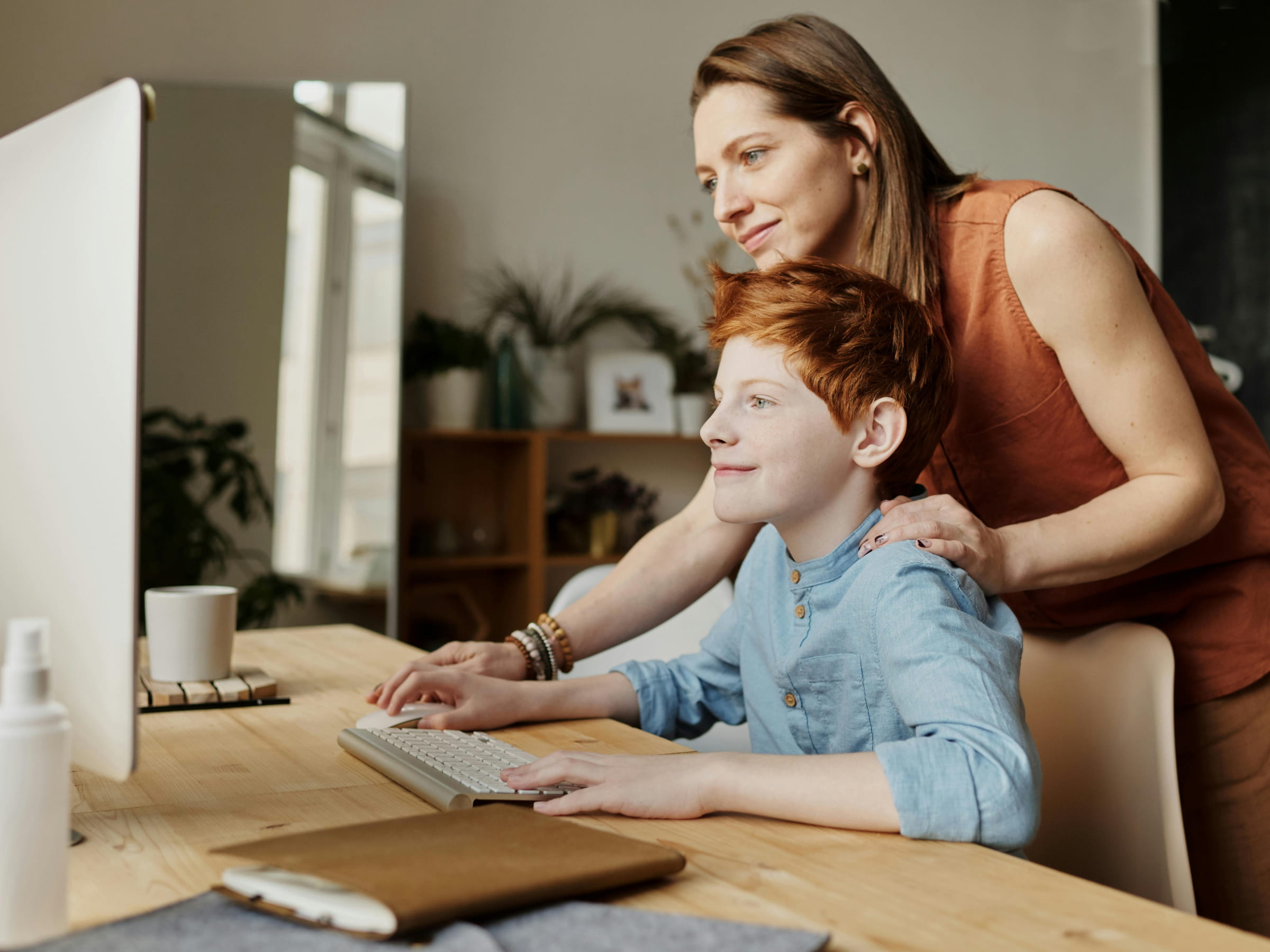 Mum helping son on computer